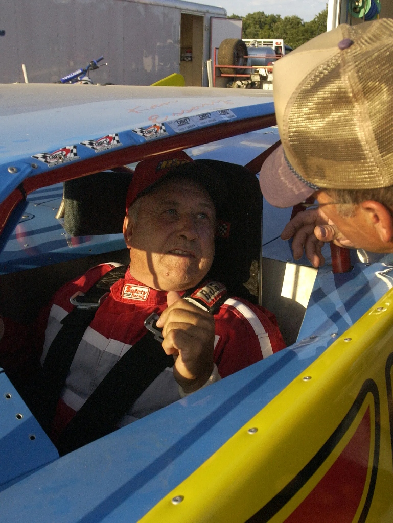 Ken 'Flyin' Farmer' Essary, local racing legend, standing beside his dirt track race car